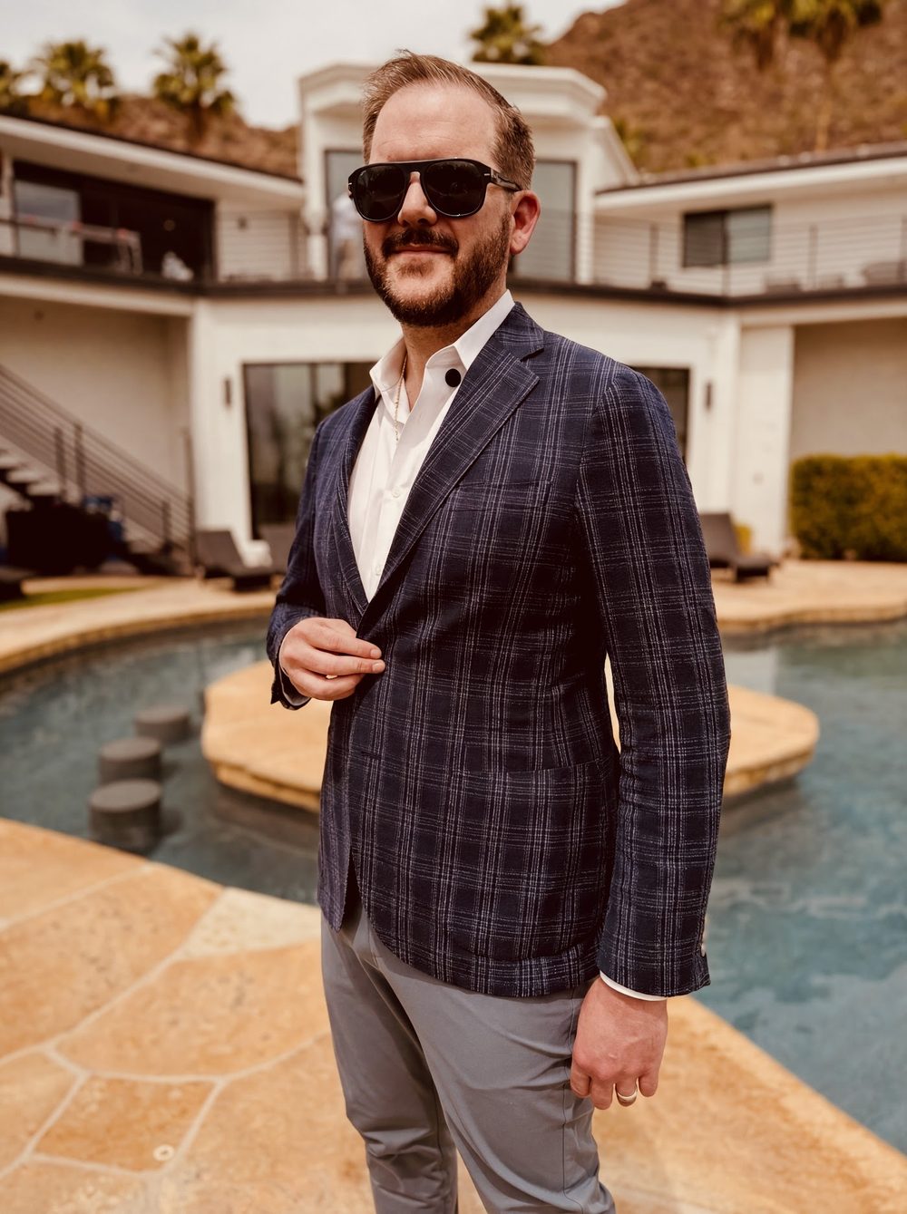 A sharply dressed Button Up operator at a modern poolside property